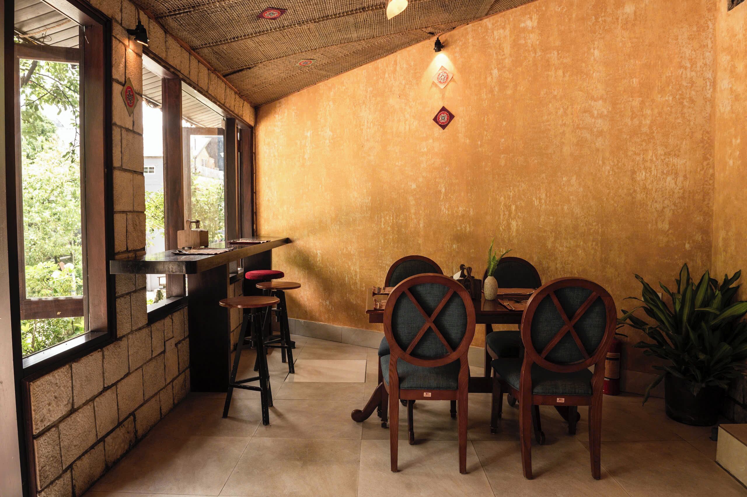 A cozy dining area with brick walls, wooden chairs, and a table.