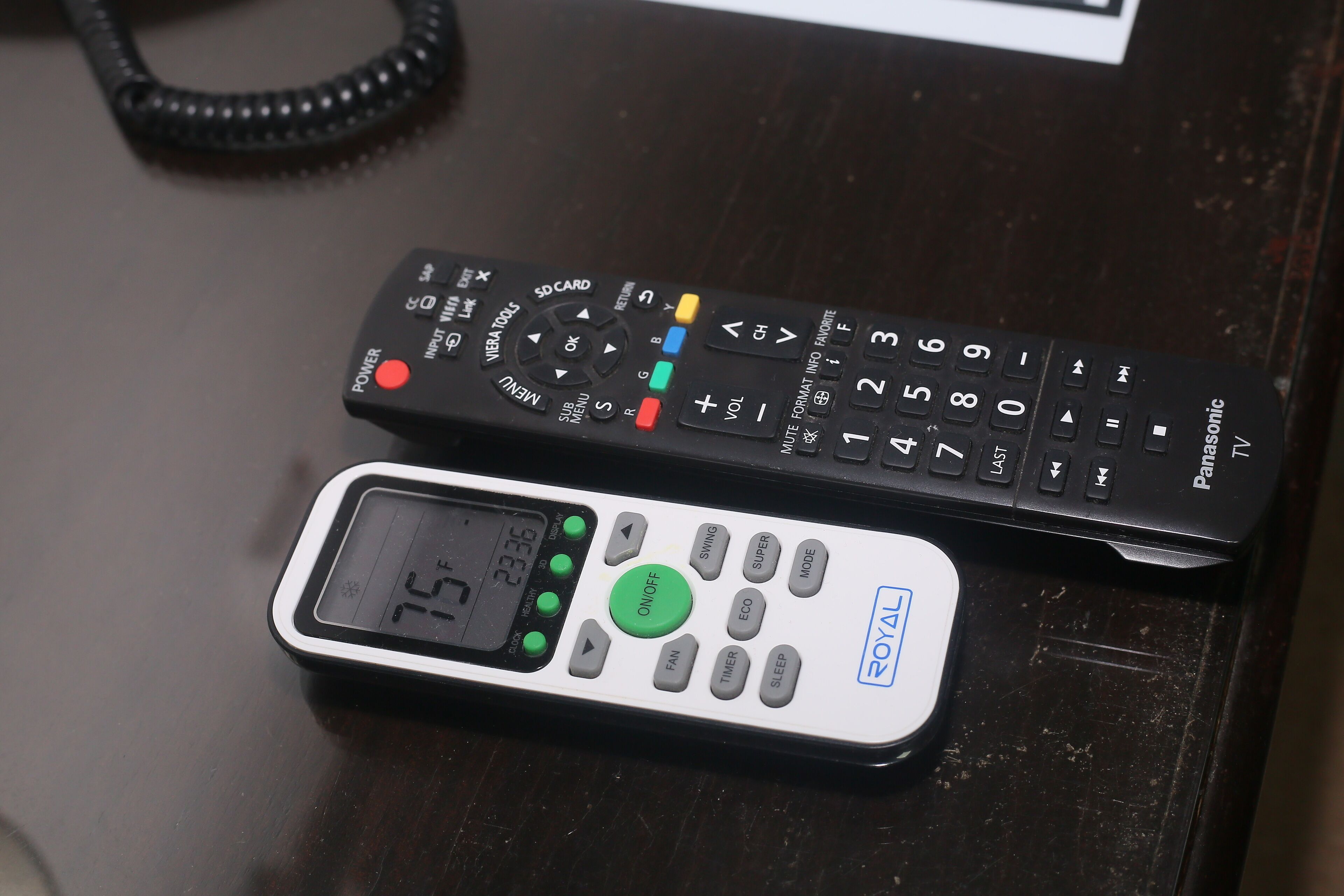 Deux télécommandes sur une surface en bois sombre.