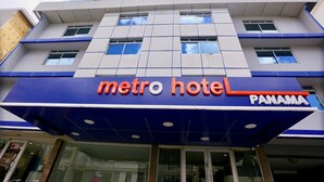 A hotel named Metro Hotel Panama with a modern facade, large windows, and a prominent blue and orange sign. - Metro Hotel Panama (Panama City)