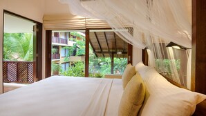 Un dormitorio con una cama grande, vistas a un balcón y una mosquitera.