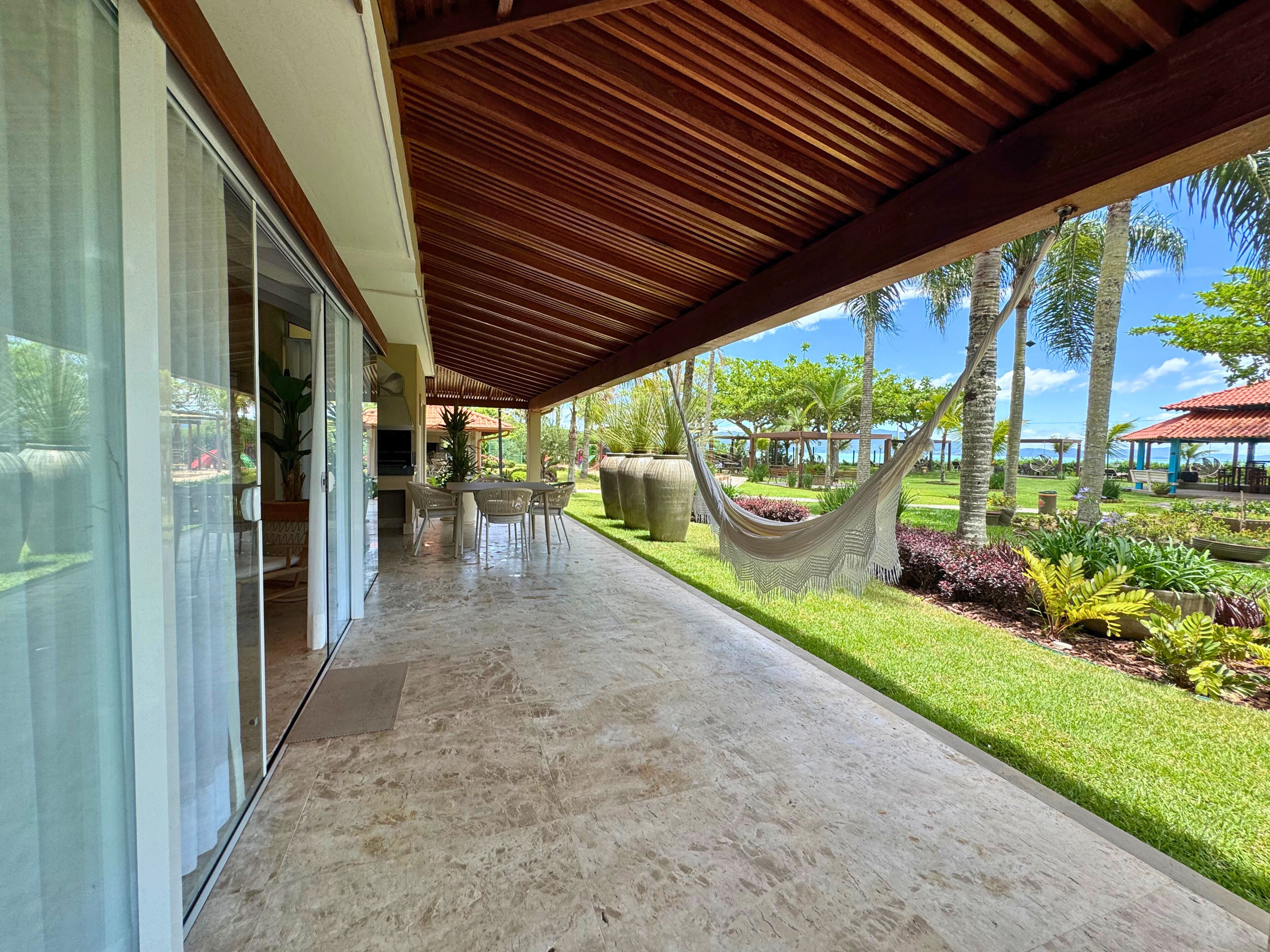 A covered outdoor area with a patio, seating, and a hammock.
