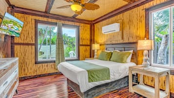 A wooden-themed bedroom with a bed, bedside tables, and a ceiling fan.