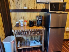 Una kitchenette equipada con microondas, cafetera, tostadora y refrigerador.