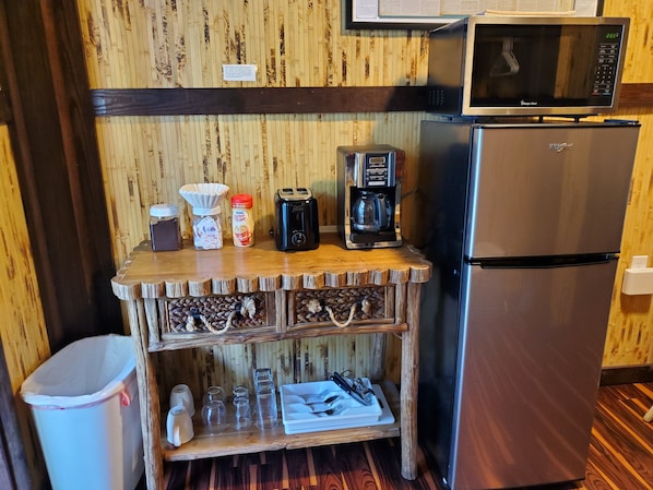 A kitchenette with a microwave, coffee maker, toaster, and a refrigerator. - Captain Pips Marina & Hideaway (Marathon)