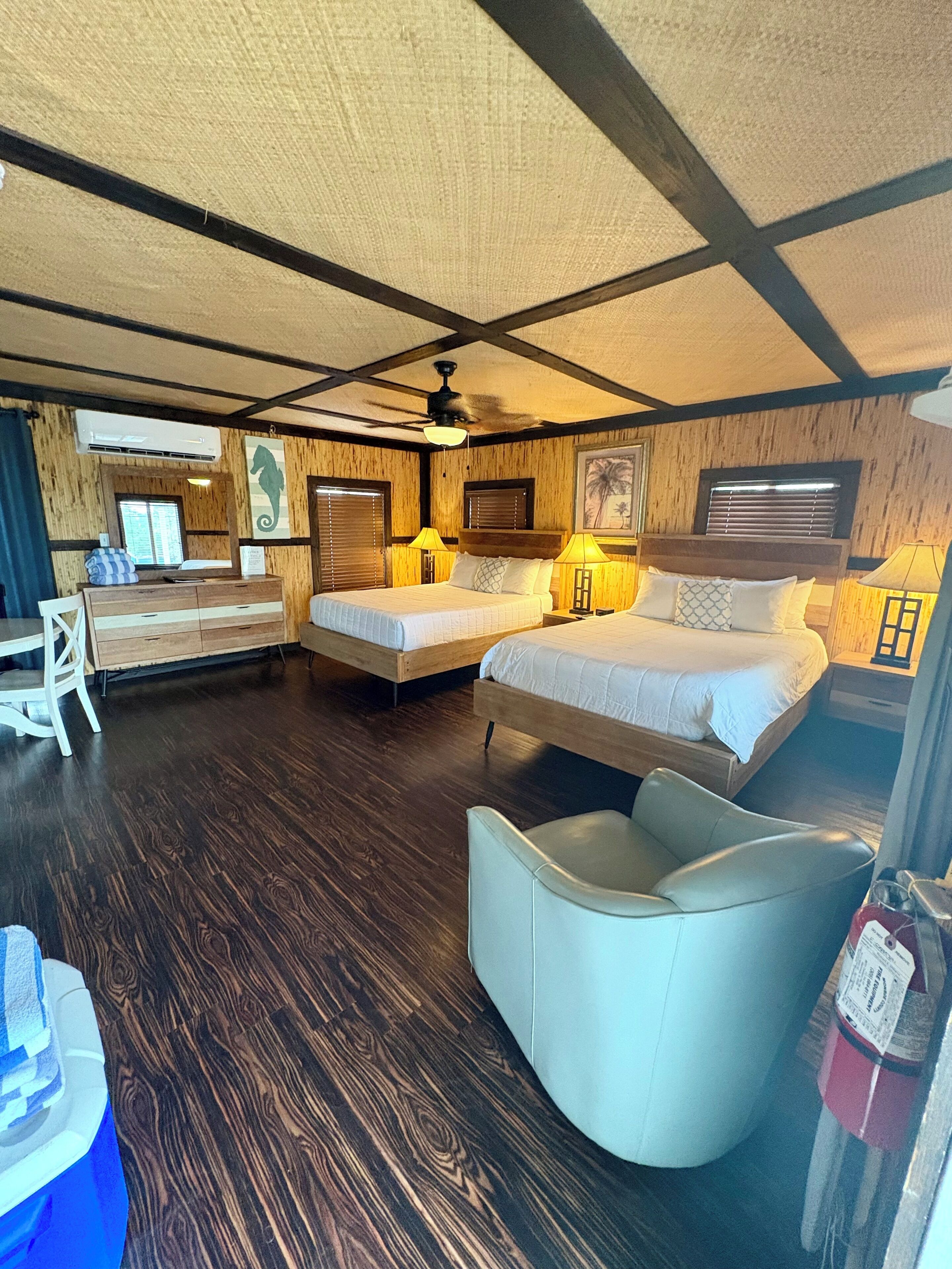 Une chambre d’hôtel avec deux lits, un bureau et une chaise.