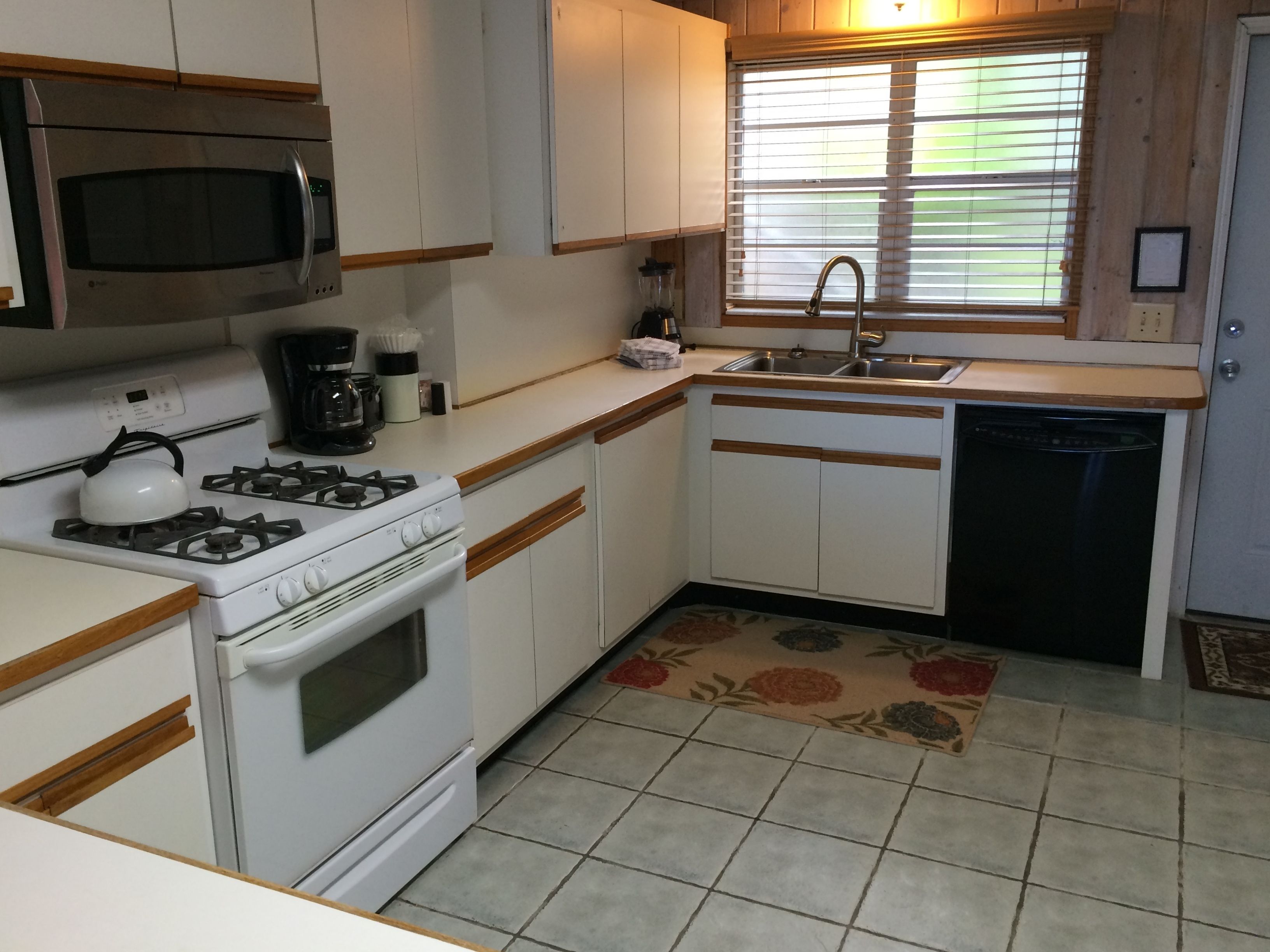 A compact kitchen with a gas stove, microwave, and dishwasher.