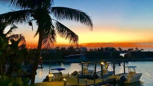 A waterfront dock with boats and a sunset. - Captain Pips Marina & Hideaway (Marathon)