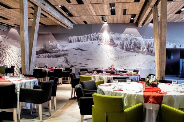 A restaurant with multiple tables set for dining, featuring a large mural of a snowy landscape on the wall. - Aparthotel Vučko (East Sarajevo)
