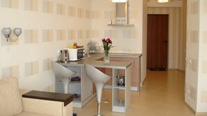 A modern kitchen with a microwave, kettle, and a vase of flowers on the counter. - Most City Premium apartments (Dnipro)