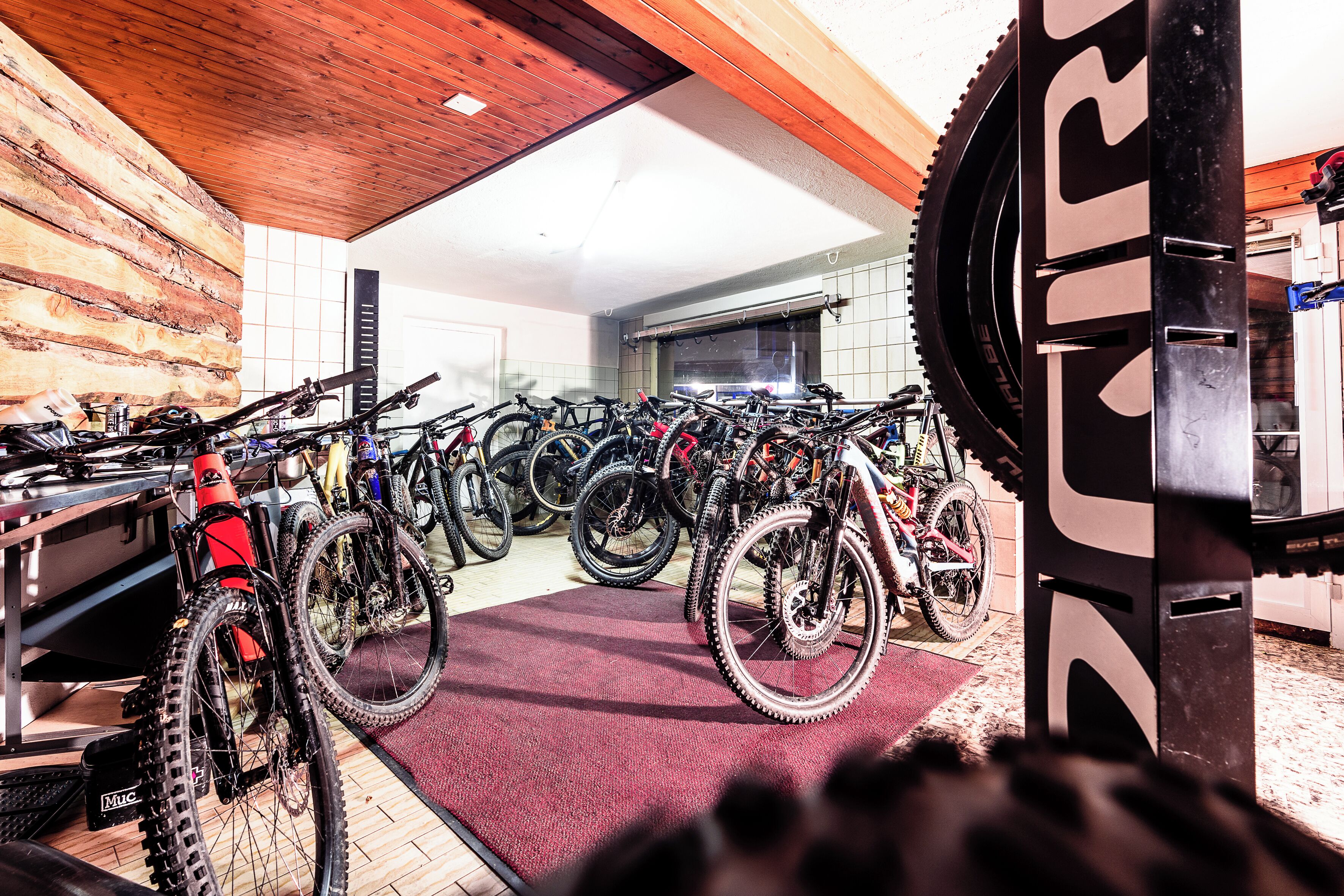 A bike rental shop with multiple bicycles and a large gear wheel.