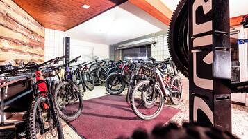 A bike rental shop with multiple bicycles and a large gear wheel.