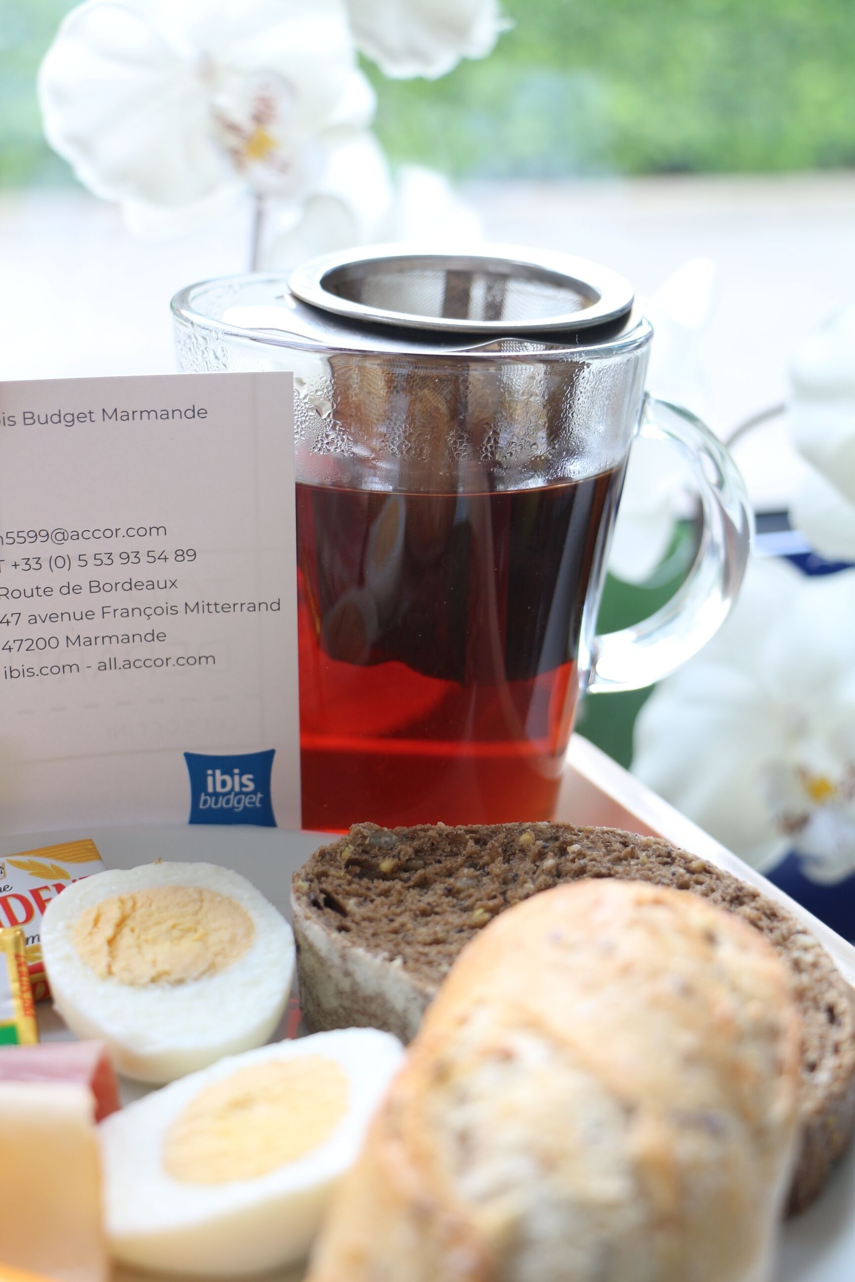Eine Tasse mit Tee, eine Brotscheibe und ein halbiertes Ei auf einem Tablett.