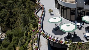 Terraza en la azotea con mobiliario exterior y barandilla curva.