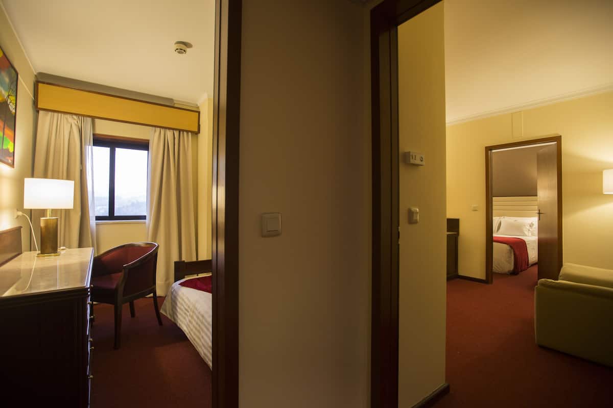 Ein Hotelzimmer mit Schreibtisch, Stuhl, Bett und Spiegel.