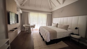 A modern hotel room with a large bed, a desk, and a TV.
