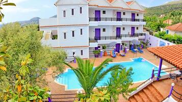 Alberca al aire libre, sombrillas en la alberca y camastros