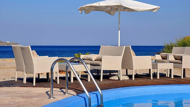 A poolside area with lounge chairs and an umbrella, overlooking the sea. - Tony's Beach (Leros)