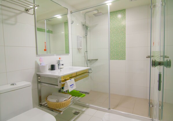 A modern bathroom with a glass shower enclosure, a white sink, and a toilet. - Legend Hotel Liuhe (Kaohsiung)