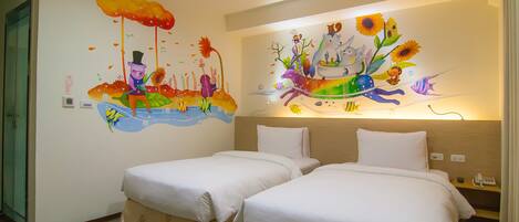 Habitación de hotel con dos camas, un mural en la pared y una mesita de noche con un teléfono.
