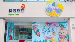 The exterior of the Legend Hotel with a colorful mural on the wall and a red carpet leading to the entrance. - Legend Hotel Liuhe (Kaohsiung)