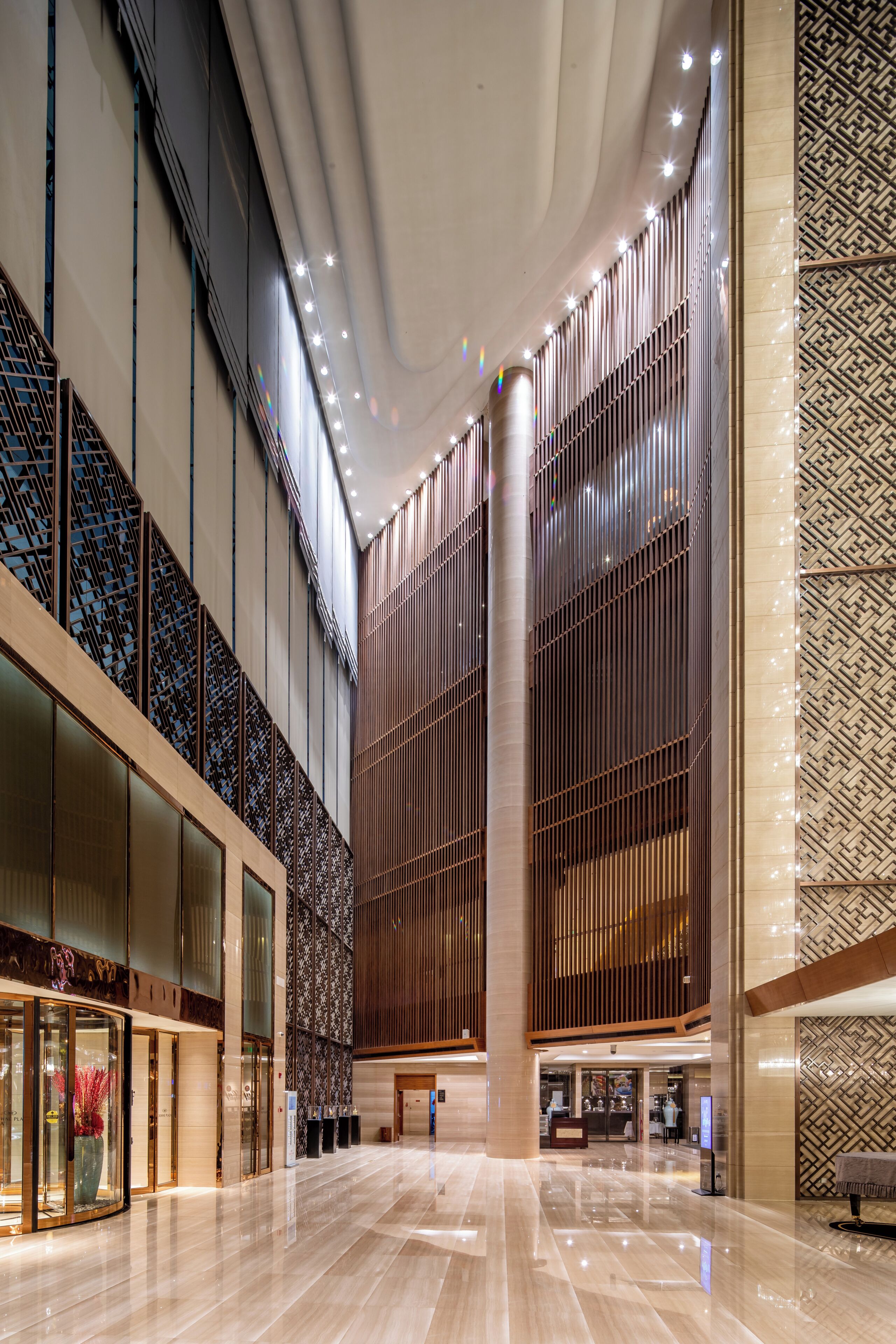 A spacious lobby with a high ceiling, large windows, and a modern design.