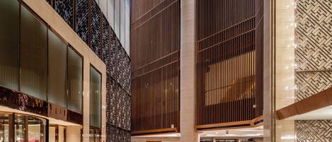 A spacious lobby with a high ceiling, large windows, and a modern design.