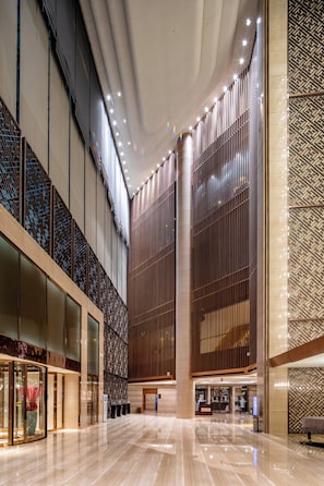 A spacious lobby with a high ceiling, large windows, and a modern design. - Crowne Plaza Xian by IHG (Xi'an)