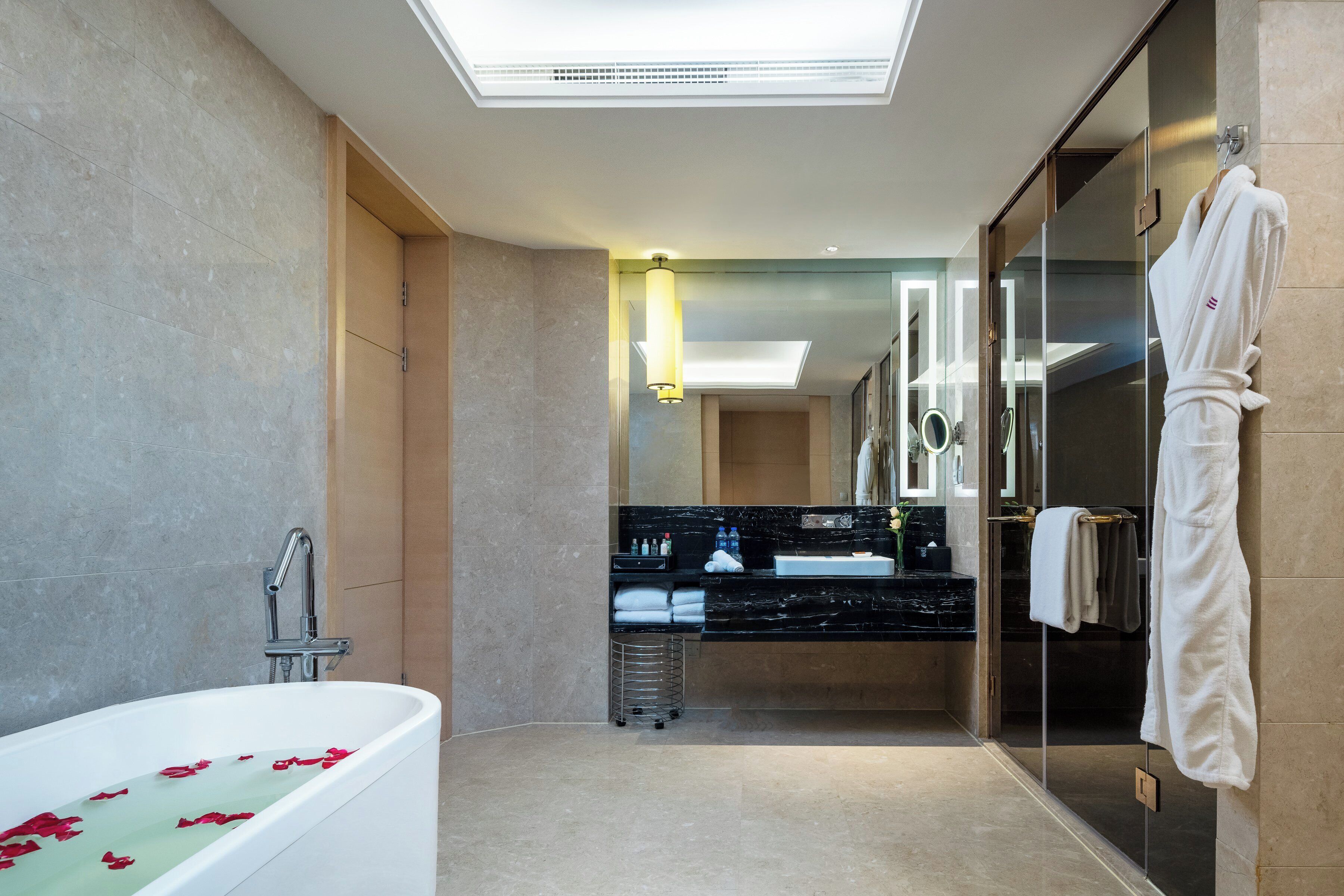 A modern bathroom with a bathtub, a glass shower enclosure, and a vanity with a mirror.
