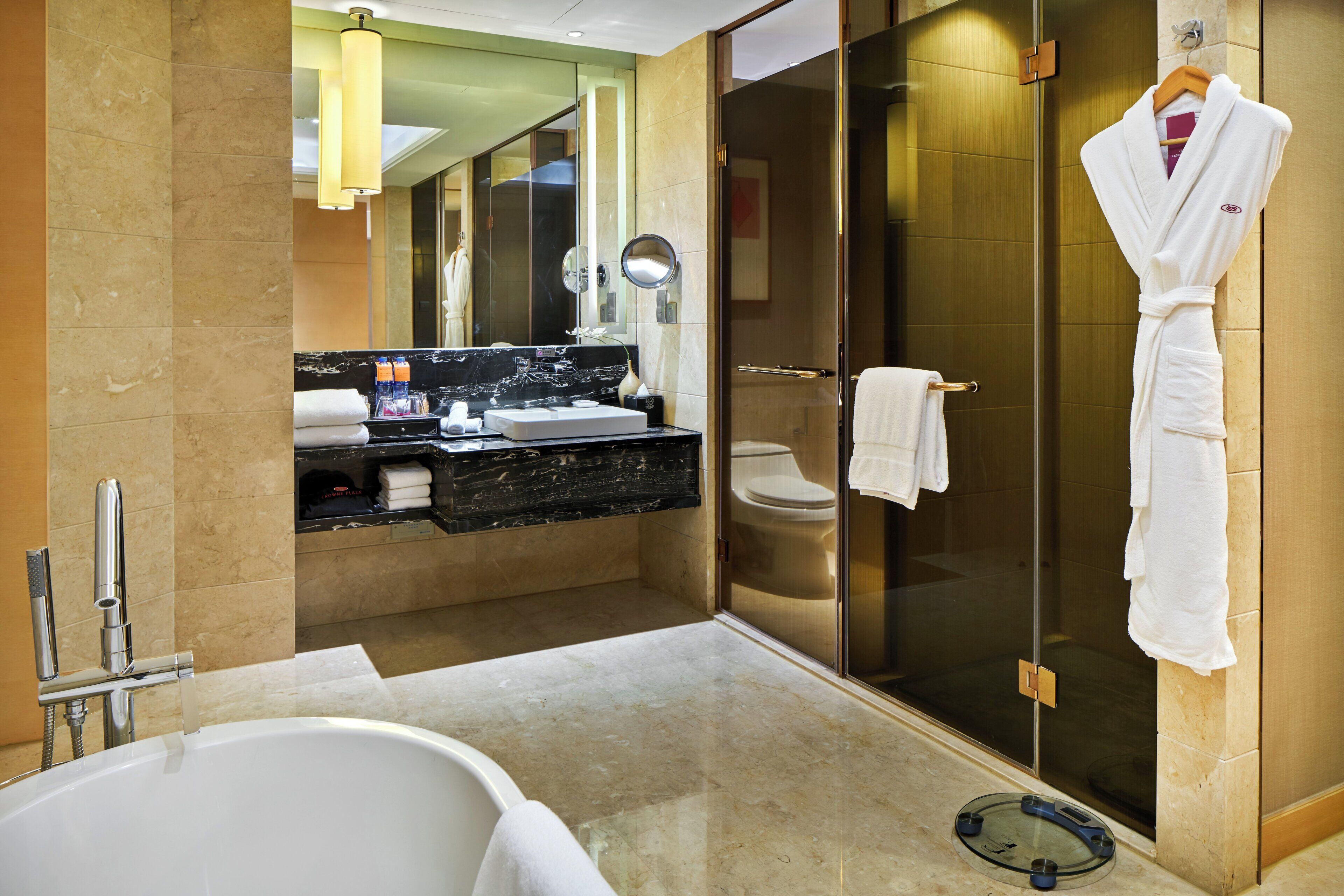 A modern bathroom with a bathtub, a glass-enclosed shower, and a vanity with a mirror.
