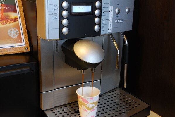 Una cafetera sirviendo café en una taza.