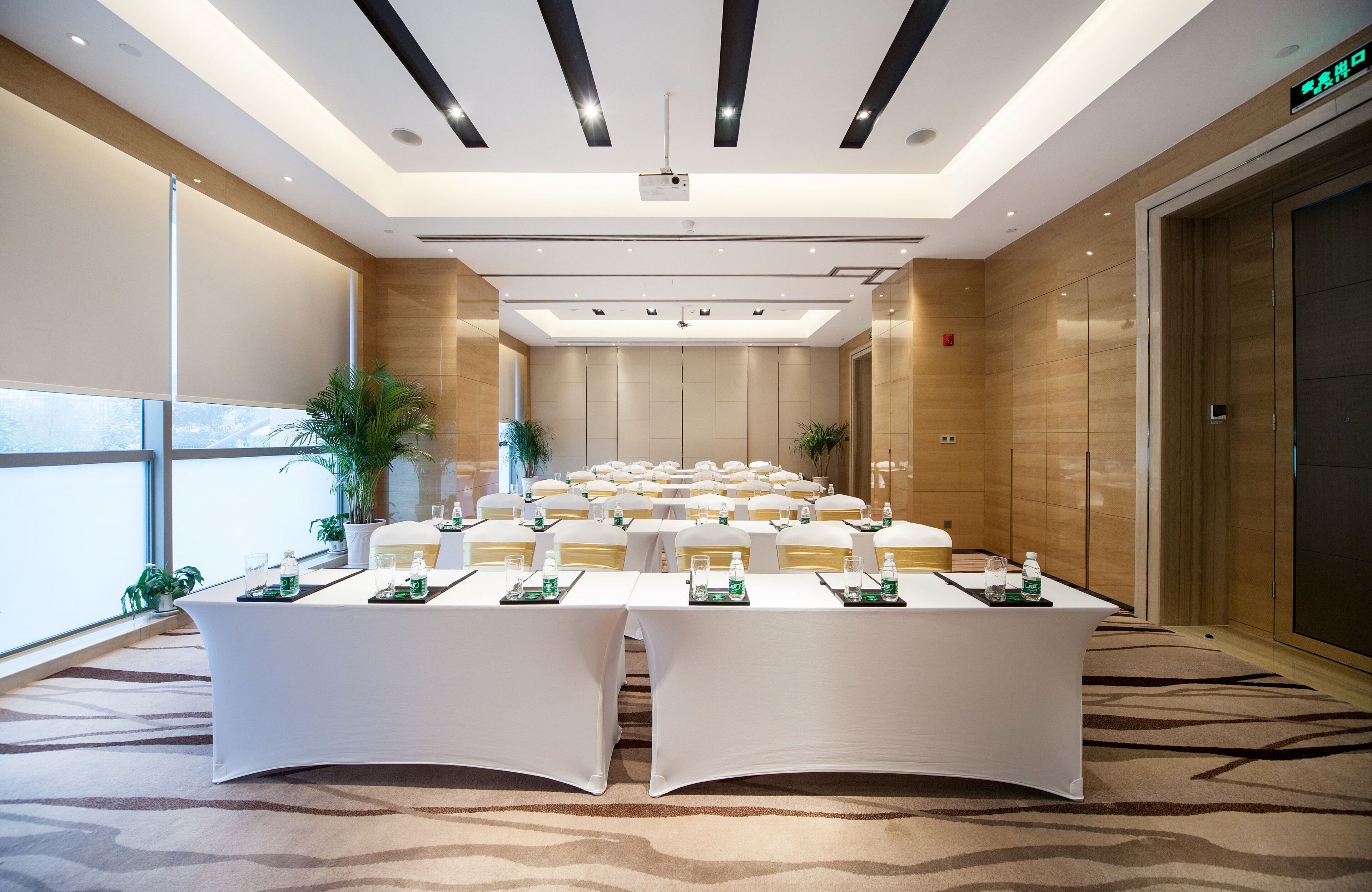A conference room with a long table, chairs, and a projector.