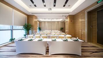 A conference room with a long table, chairs, and a projector.
