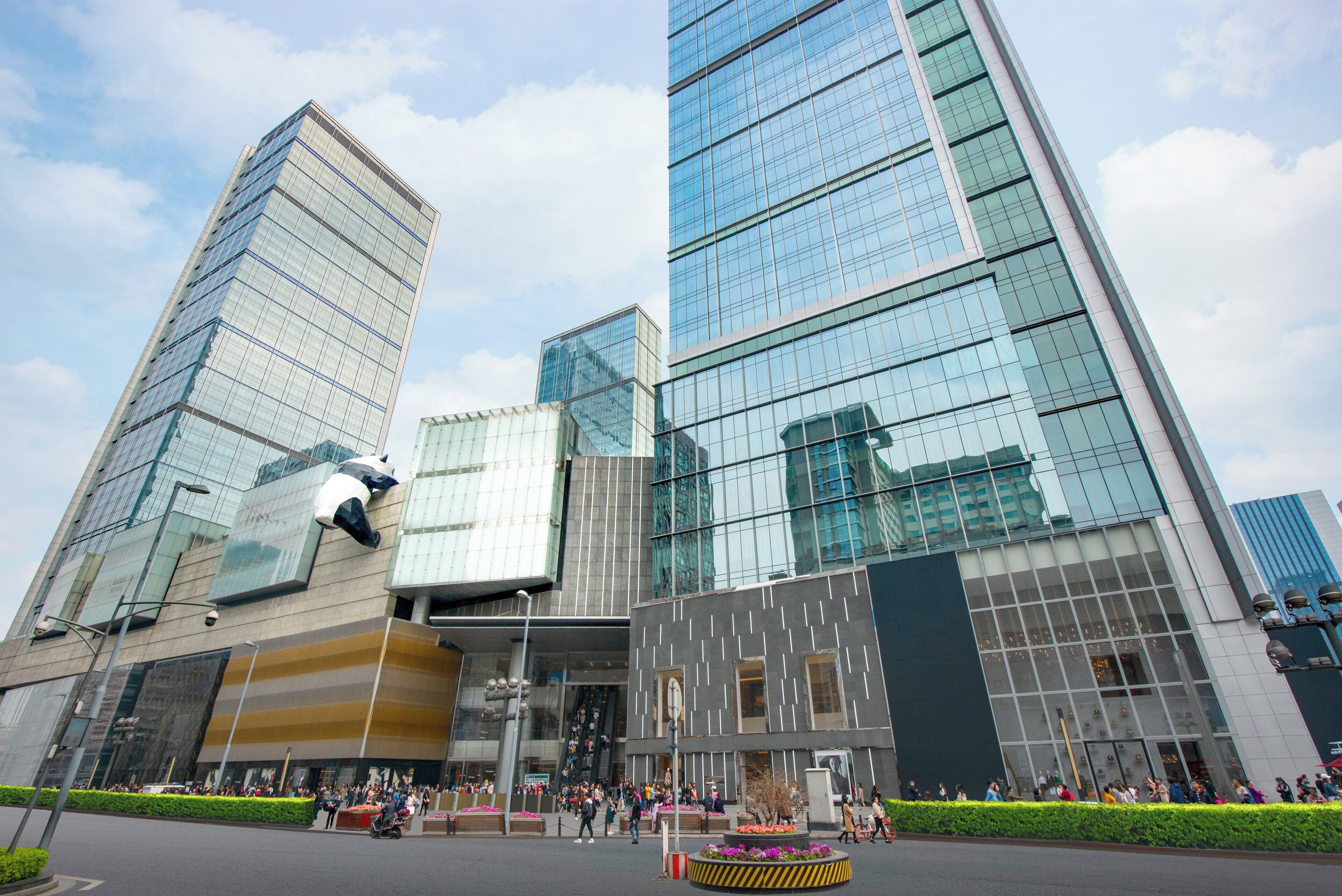 Un edificio moderno con múltiples fachadas de vidrio y una entrada central.