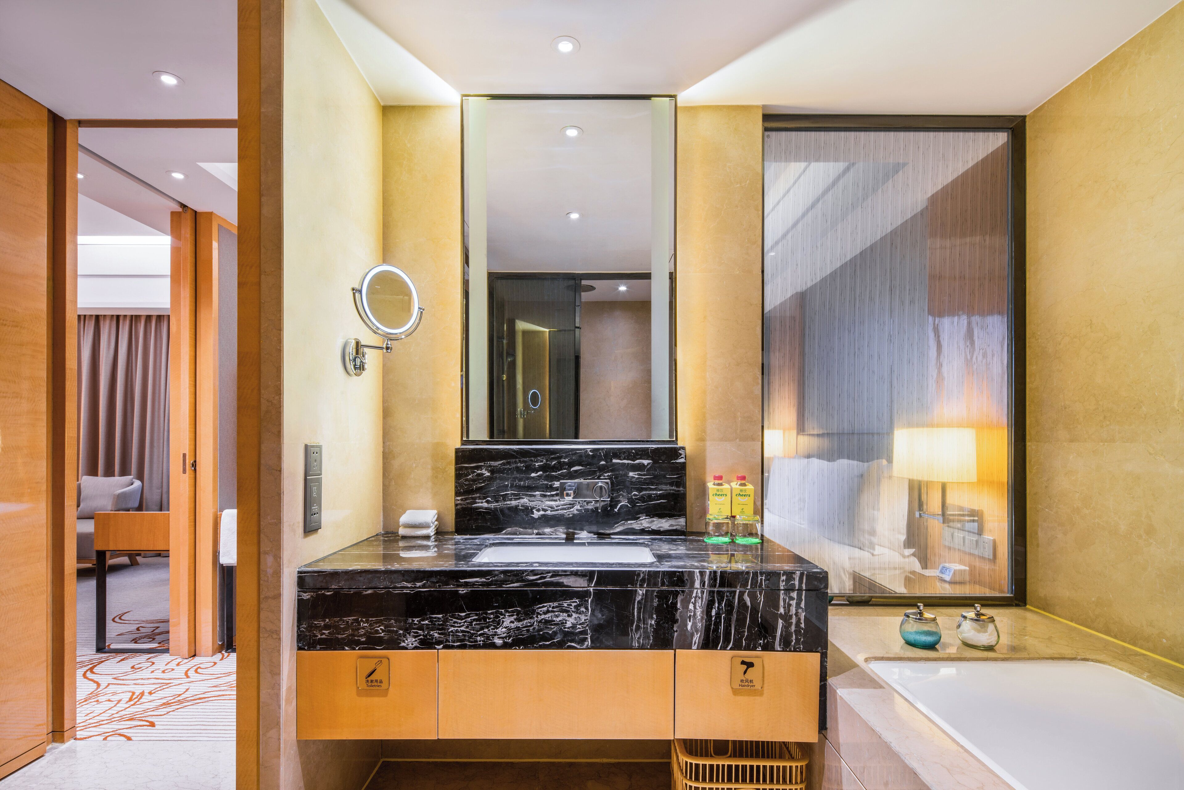 Ein modernes Badezimmer mit einem schwarzen Marmorwaschbecken, einem großen Spiegel und einer Badewanne.