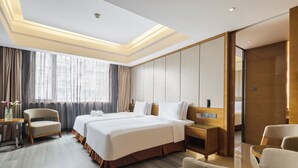 A hotel room with a large bed, a desk, a chair, and a large window with curtains. - Holiday Inn Chengdu Oriental Plaza by IHG (Chengdu)