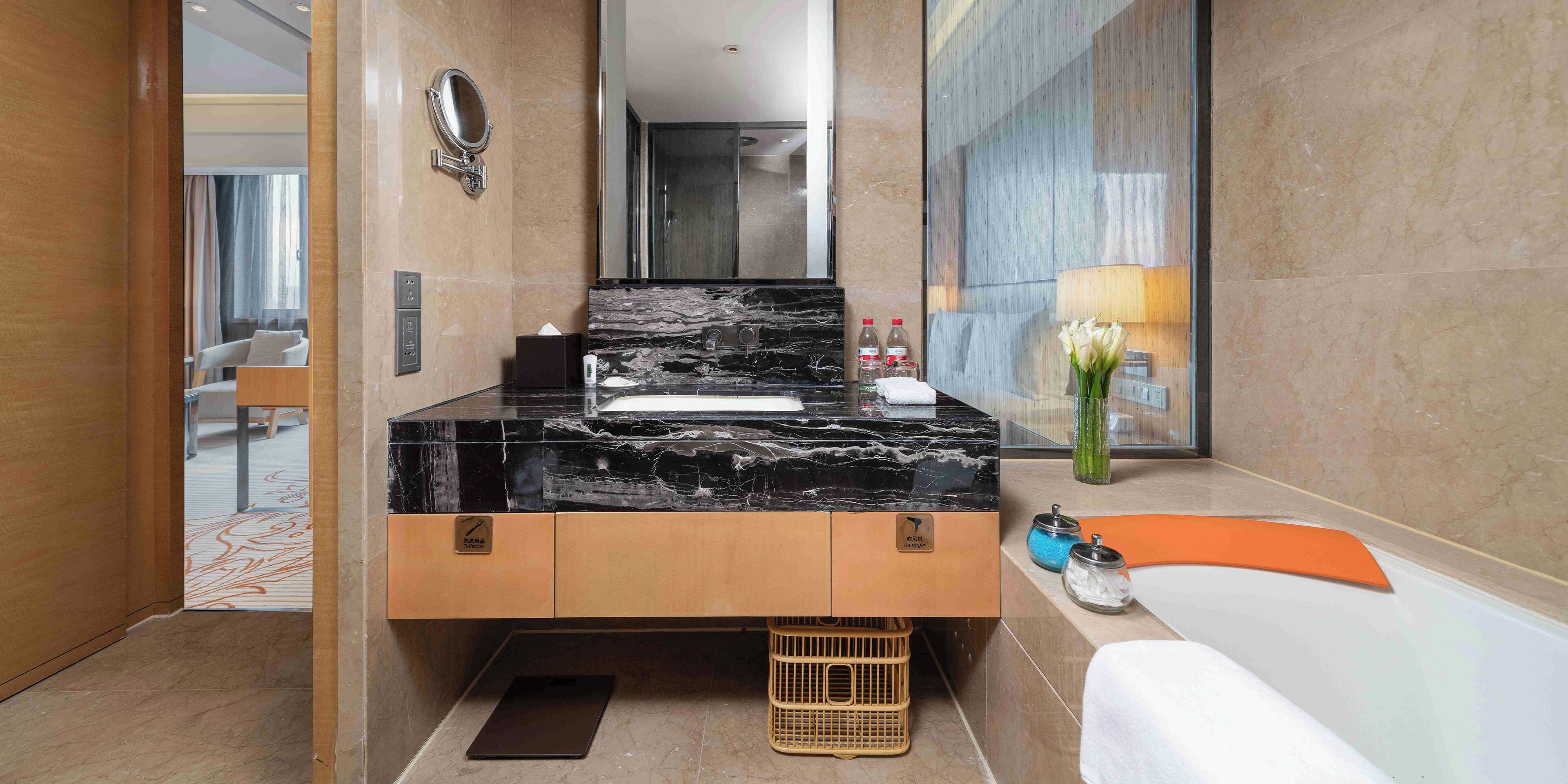 A modern bathroom with a marble sink, a mirror, a towel rack, and a toilet.