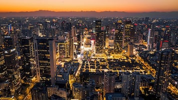 A cityscape at dusk with illuminated buildings and a clear view of the urban layout.