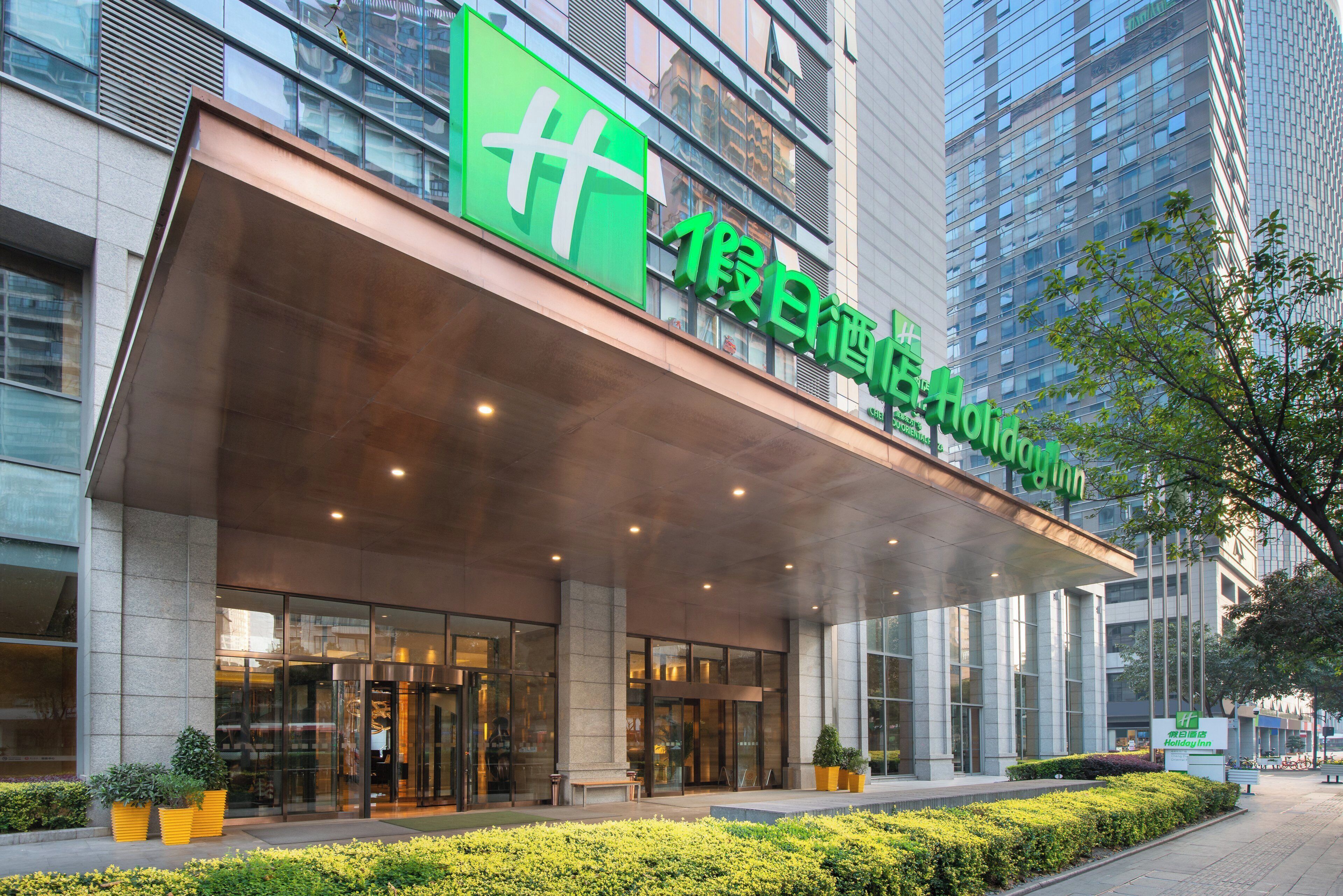 Um edifício moderno com uma grande placa verde para Holiday Inn.