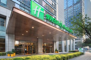 A modern building with a large green sign for Holiday Inn. - Holiday Inn Chengdu Oriental Plaza by IHG (Chengdu)