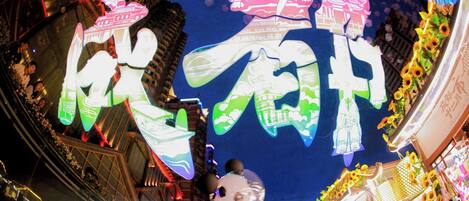 A view of a building facade with illuminated Chinese characters and traditional architectural elements.