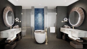 Un baño moderno con dos lavamanos, una bañera amplia y una pared de acento azul.