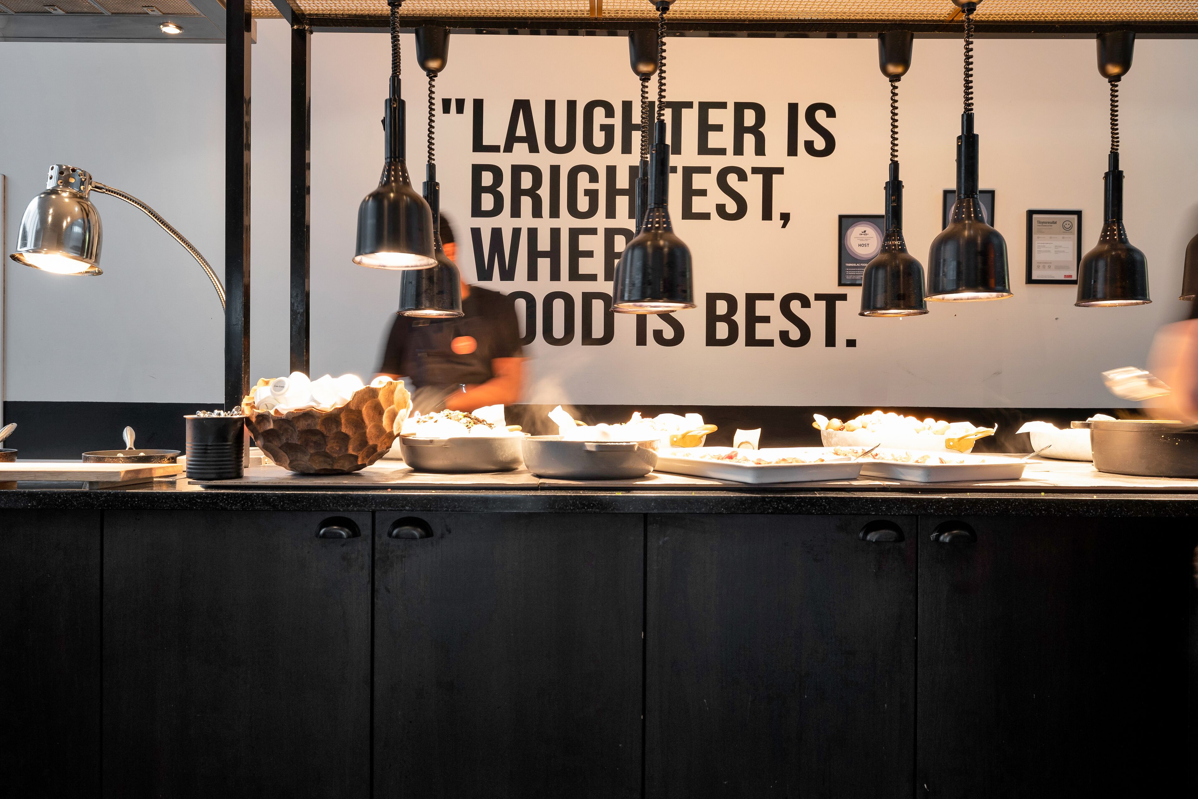 A buffet area with various dishes and a quote on the wall.
