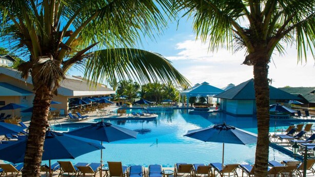 A pool area with multiple pools, sun loungers, and umbrellas. - Infinity Blue Resort & Spa (Balneário Camboriú)