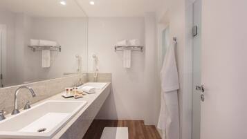 Un baño moderno con dos lavamanos, un espejo grande y suelo de madera.