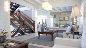 A spacious living room with a staircase, a coffee table, and a sofa. - Infinity Blue Resort & Spa (Balneário Camboriú)