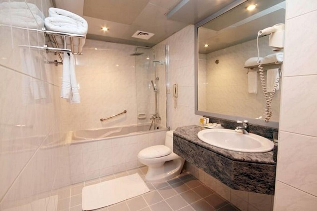 A modern bathroom with a bathtub, a toilet, and a sink.