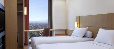 A hotel room with two beds, a TV, a wardrobe, and a large window with a city view.
