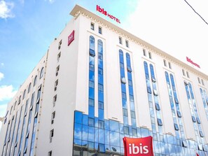 A hotel building with the 'ibis' logo, multiple windows, and a clear sky. - ibis Tunis (Tunis)