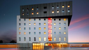 A modern hotel with a prominent vertical glass feature, multiple windows, and a 'RESTAURANT' sign. - Comfort Hotel Olomouc Centre (Olomouc)