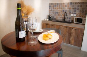Una mesa de comedor con una botella de vino, dos copas y un plato con pasteles.